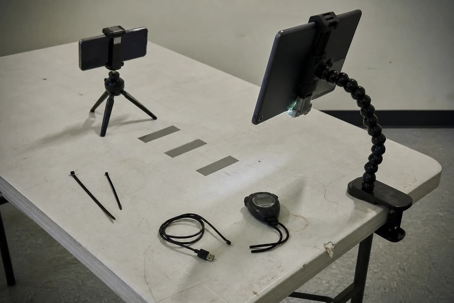 A temporary test rig with a phone and tablet on adjustable mounts set up to validate a prototype