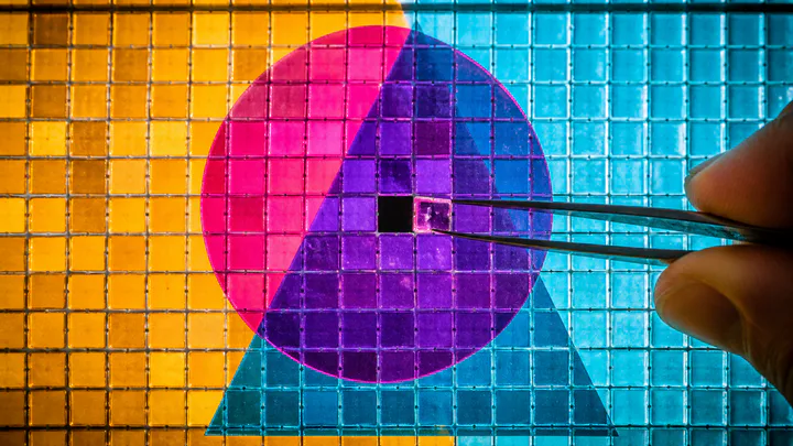 Tweezers lifting one glowing pixel from overlapping color shapes on a lightbox