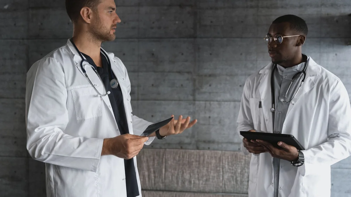 Two medical professionals discuss tablets during a focused healthcare work session